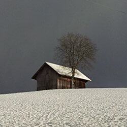 Scheune auf schneebedeckter Wiese