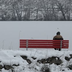 Spaziergänger auf der Bank am Seeufer